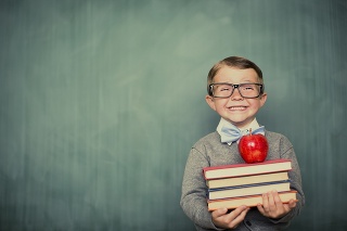 A young and vintage student is ready to learn at school. First, he will give his teacher an apple.