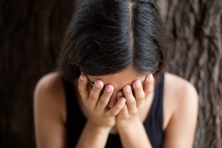 A young Hispanic woman showing signs of depression in this horizontal shot.