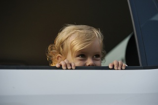 Portrait happy smiling little child sitting in white car