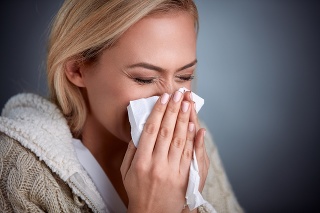 Cold woman holding handkerchieif blowing nose