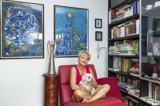 Dagmar so psím miláčikom Blškou a s knihami, ktoré miluje. Obrazy na stene sú jej diela.