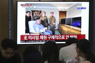Ľudia sledujú televízne správy, na obrazovke je severokórejský vodca Kim Čong-un.