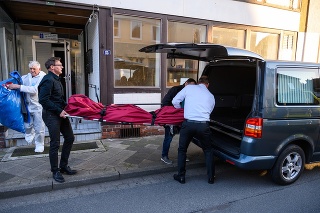 Pracovníci pohrebnej služby nakladajú telo jednej z dvoch mŕtvych žien, ktoré polícia objavila v meste Wittingen.