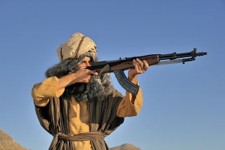 Bearded Man In Turban and Robes Holding Russian Rifle. Shallow Depth Of Field. Space For Copy.