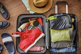 Prepare accessories and travel items. Open traveler's bag with clothing, accessories, and passport. Travel and vacations concept