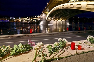 Na nábreží Dunaja kladú ľudia kvety, aby si uctili pamiatku obetí.