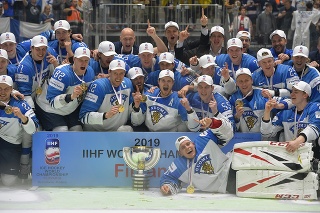 Na snímke fínski hokejisti pózujú s trofejou a zlatými medailami.