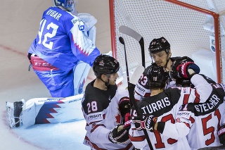 Na snímke vľavo prekonaný Patrik Rybár (Slovensko) a vpravo gólová radosť Kanaďanov po piatom góle.
