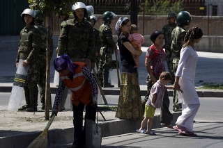 Obyvatelia v Ujgurskej autonómnej oblasti Sin-ťiang a čínski policajti.