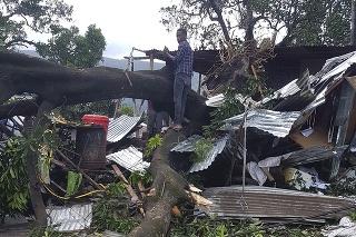 Muž odstraňuje škody po cyklóne Kenneth na Komorských ostrovoch.