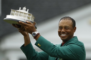 Americký golfista Tiger Woods pózuje v zelenom saku s trofejou po výhre na turnaji v Augusta National Golf Club.