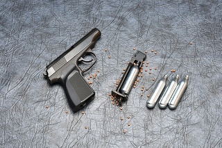 Pneumatic pistol on a grey background.