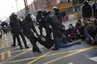 Policajti rozohnávajú demonštrantov, ktorí blokujú cestu vedúcu do Barcelony.