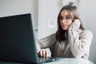 Beautiful young woman wearing eyeglasses using computer