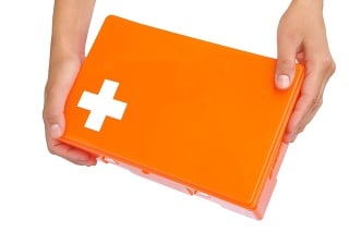 Hands of young woman holding closed first aid kit - isolated