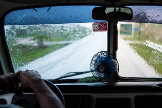 Pinar del Rio, Сuba - July 19, 2015: During a summer storm, the bus driver uses a portable fan to get air. It works only on the left wiper and glasses are of different colors because of the embargo.