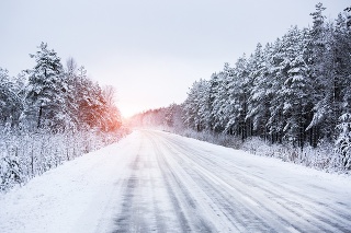 Winter road through the forest in countryside.
