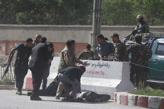 Na snímke z 30. apríla ľudia pomáhajú afganskému novinárovi po útoku v Kábule.