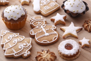 Assorted gingerbread cookies decorated with sugar icing on wooden table.