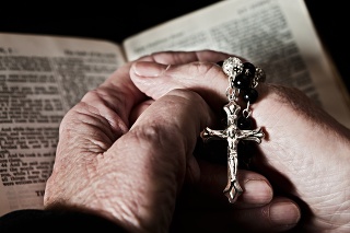Close up of very old hands, holding a rosary,  clasped over an equally old  Bible. Faith in action. Shot with Canon EOS 1Ds Mark III.