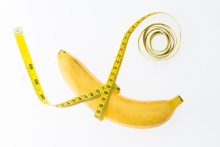 Banana with tape measure isolated on white background.