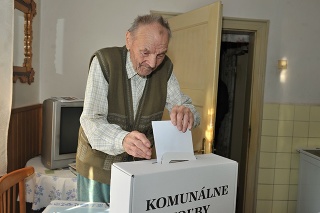 94-ročný volič Adam Cingel vhadzuje v obci Terchováí do prenosnej volebnej schránky obálku s hlasovacím lístkom.