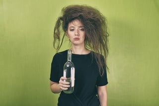drunk girl with a bottle of wine on a yellow background