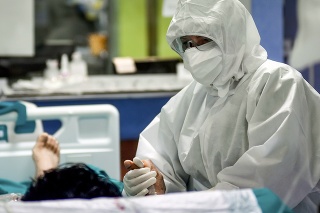 Pohľad na zdravotníka držiaceho za ruku pacienta v jednej z nemocníc neďaleko Milána.