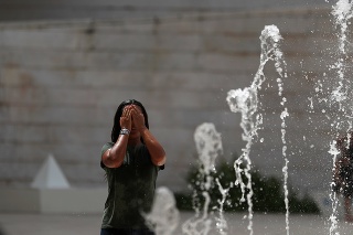 Žena sa osviežuje vo fontáne v Lisabone.