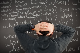 Young man thinking in front of blackboard