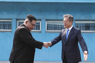 Severokórejský vodca Kim Čong-un (vľavo) a juhokórejský prezident Mun Če-in si podávajú ruky v dedine Pchanmundžom ležiacej v demilitarizovanej zóne.