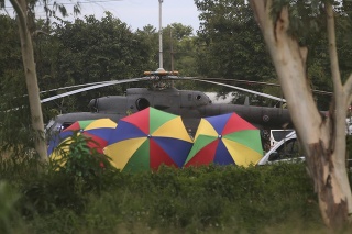 Polícia rozmiestnila dáždniky okolo helikoptéry počas evakuácie zachránených detí.