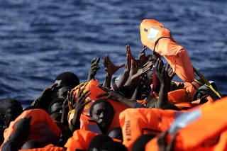 Migranti sa naťahujú za záchrannými vestami.