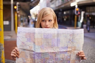 Shot of a young woman holding a map while touring abroad