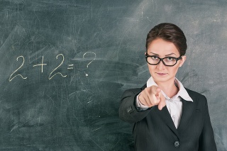 Woman teacher in glasses teaching maths and pointing on someone