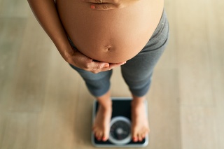 Cropped high angle shot of a pregnant woman weighing herself on a scale