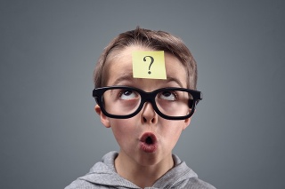 Confused boy thinking with question mark on sticky note on forehead