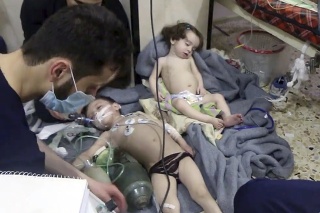 Na snímke zverejnenej Sýrskou civilnou obrannou skupinou Biele helmy, zdravotníci poskytujú deťom pomoc po údajnom chemickom útoku v sýrskom meste Dúmá.