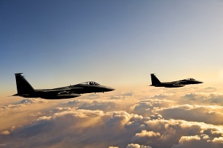 F-15 Eagle fighter jets flying above clouds at sunset