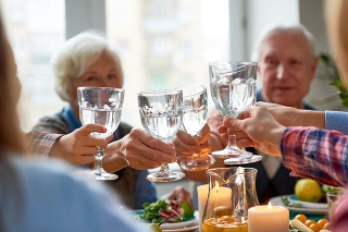 Close-up of big family drinking water and clinking glasses
