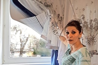 Gabriela (31) ukazuje rozbité okno, cez ktoré jej niekto hodil do bytu výbušninu.