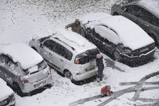 Odpratávanie snehu z áut po hustom nočnom snežení v Bratislave.
