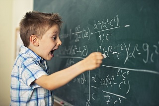 Funny little boy writing math formula. Looks like he's discovered something amazing and very important.