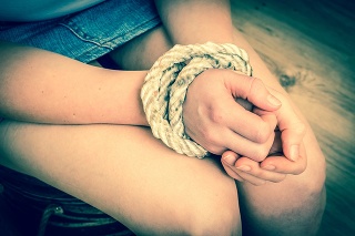 Kidnapped woman tied with rope - abuse and violence concept