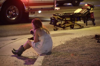  Žena sedí obrubníku na mieste  streľby, ku ktorej došlo v meste Las Vegas.