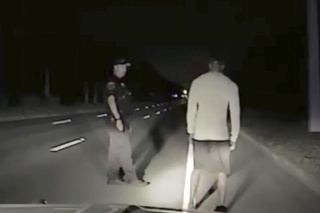 Na policajnej videosnímke Tiger Woods počas testu triezvosti po tom, čo polícia našlaa jeho auto odstavené na ceste blízko mesta Jupiter.