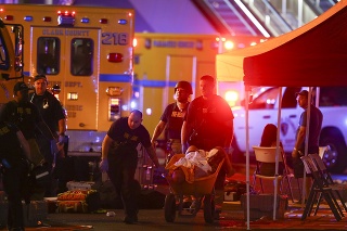 Policajti odvážajú na fúriku zranenú ženu počas streľby, ku ktorej došlo v meste Las Vegas.