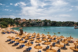 Straw umbrellas on the beach in Porto Cristo on Mallorca, Balearic Islands, Spain