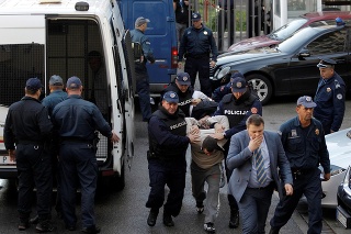 Policajti vedú jedného zo zadržaných v Podgorici.