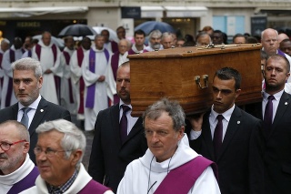 Ľudia nesú truhlu s pozostatkami zavraždeného duchovného Jacquesa Hamela pred zádušnou omšou.